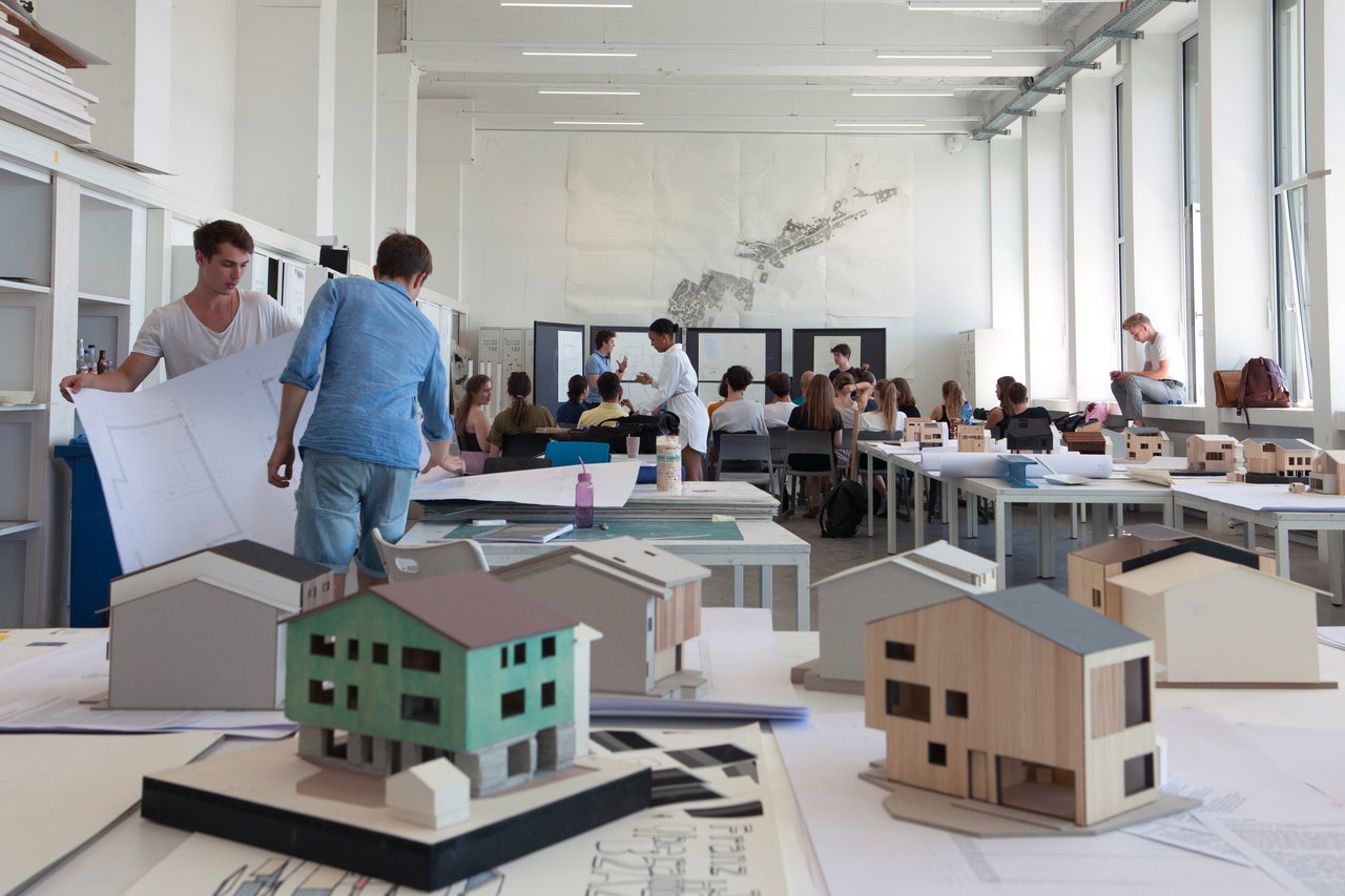 students working at a studio with architecture models in the foreground