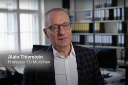 Screenshot des TV-Beitrags. Prof. Alain Thierstein ist im Porträt zu sehen. Er trägt ein weißes Hemd mitt einem schwarzen Sakko und eine Brille.