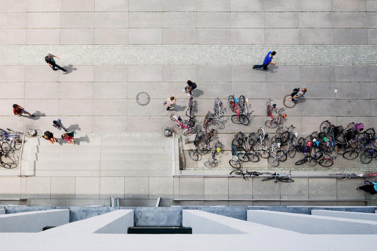 Blick von oben in Innenhof auf Fahrräder und Menschen